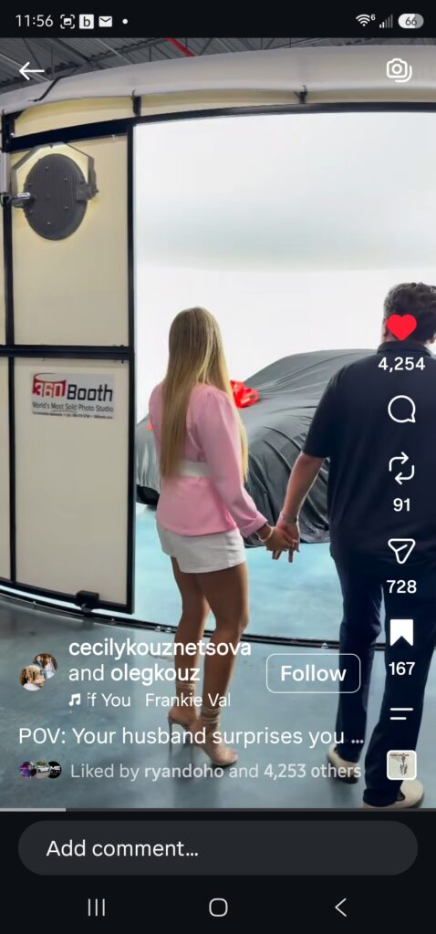 A man and a woman holding hands walk into a 360Booth where a car waits under a sheet