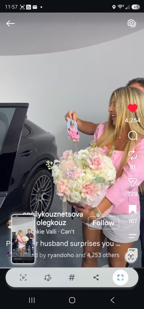 A woman holding a large bouquet of flowers reads the card that came with them