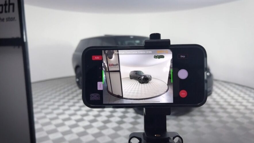 ShootIT ai taking a photo using an iPhone and a 360Booth car photo studio