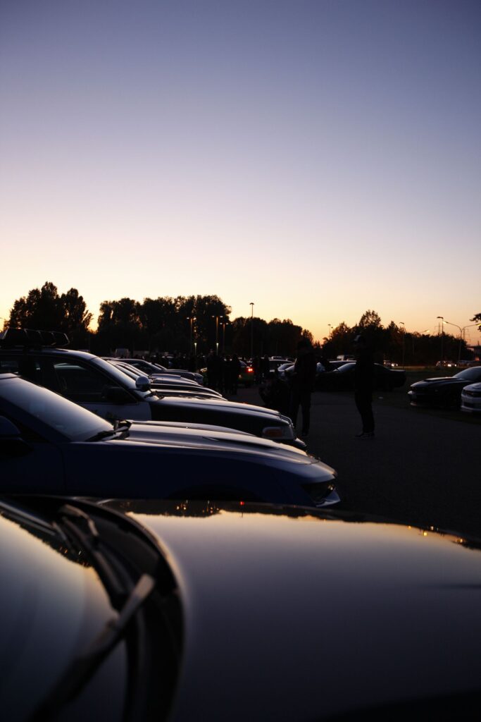 Silhouetted parked cars on an outdoor lot at dusk after sunset